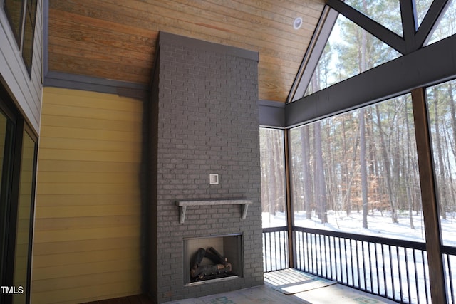 unfurnished sunroom with lofted ceiling and a fireplace