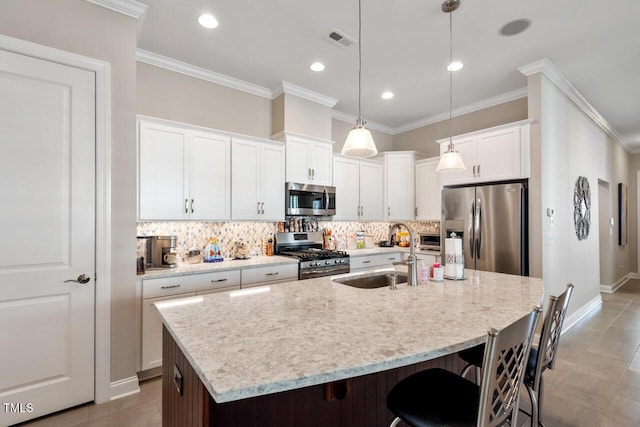 108 Boone St, Chapel Hill, NC 27516 - kitchen with visible vents, a kitchen breakfast bar, a sink, appliances with stainless steel finishes, and backsplash