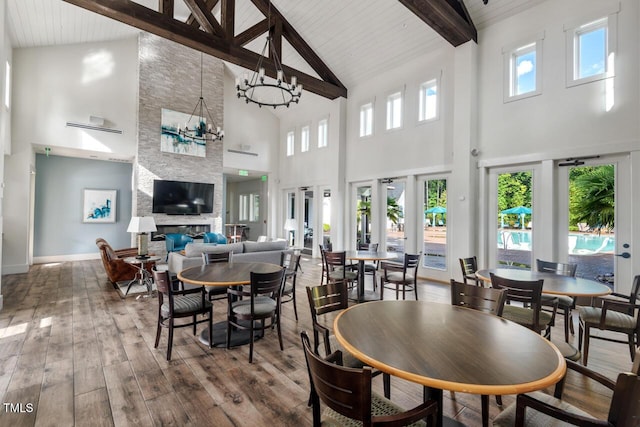 108 Boone St, Chapel Hill, NC 27516 - dining room with beam ceiling, wood-type flooring, high vaulted ceiling, a large fireplace, and french doors