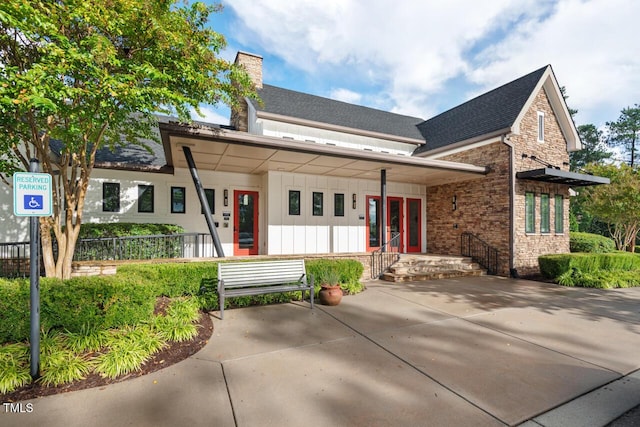 108 Boone St, Chapel Hill, NC 27516 - view of front facade featuring board and batten siding, a chimney, a shingled roof, and stone siding
