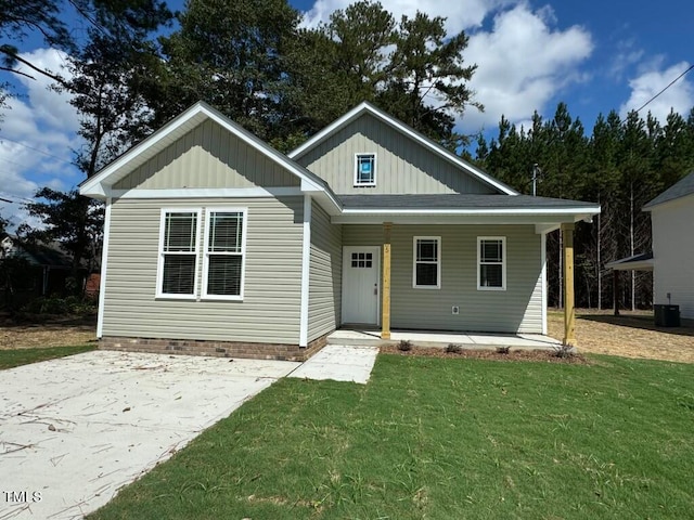 view of front of house featuring a front lawn, central AC unit, and a porch