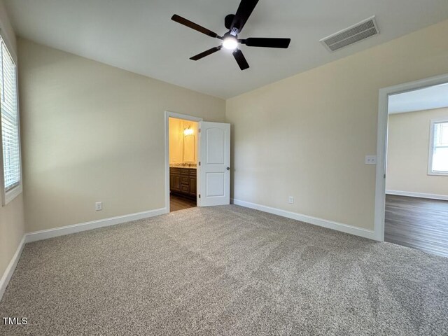 unfurnished bedroom featuring carpet floors, ensuite bath, and ceiling fan