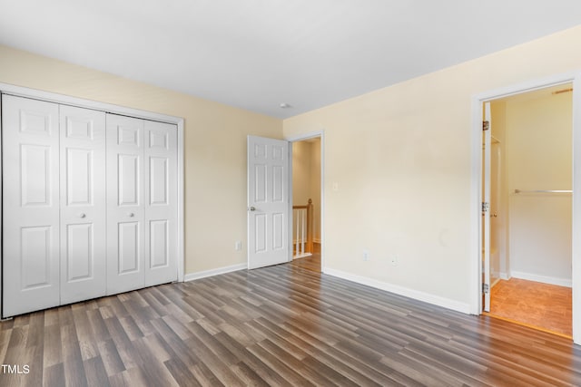 unfurnished bedroom featuring a closet and dark hardwood / wood-style floors