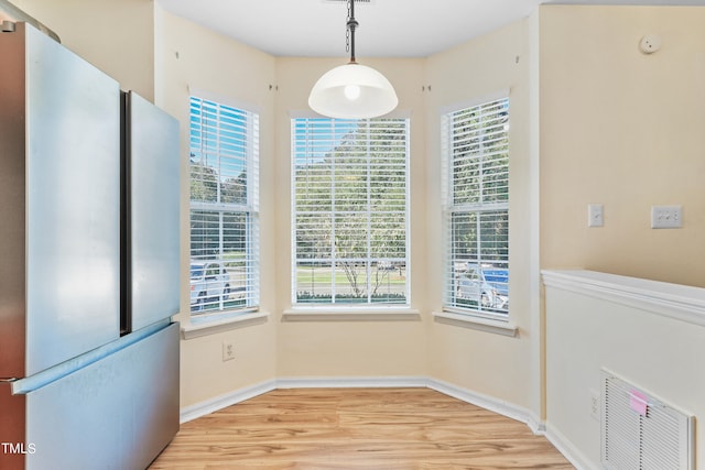 unfurnished dining area with light wood-type flooring and plenty of natural light