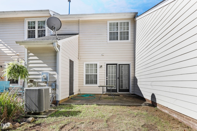 rear view of house with central air condition unit and a patio