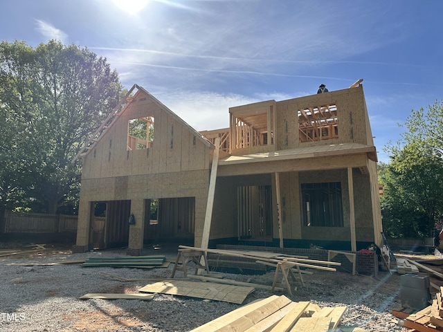 rear view of house featuring fence