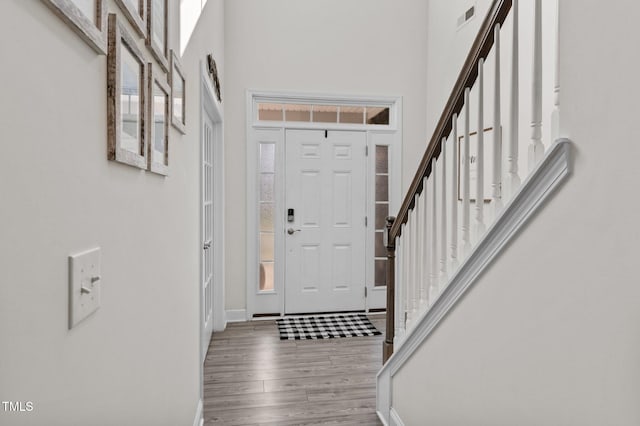 entryway with wood-type flooring and a high ceiling