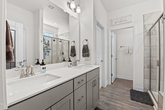 bathroom featuring walk in shower, vanity, and hardwood / wood-style flooring