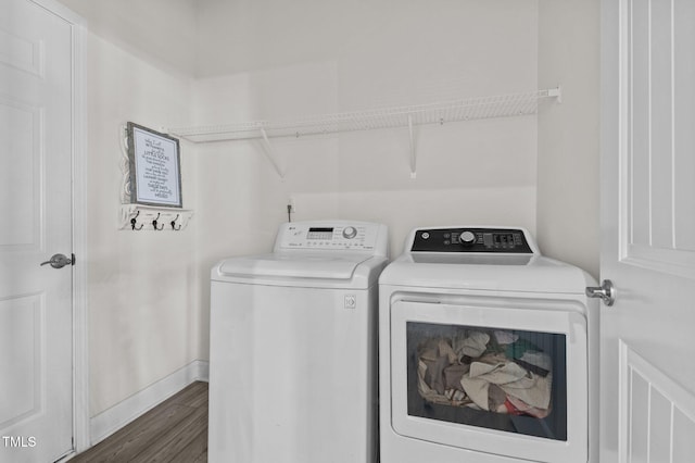 laundry room featuring washing machine and clothes dryer and dark hardwood / wood-style flooring