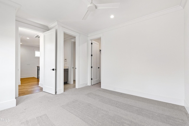 empty room featuring light carpet, ceiling fan, and crown molding