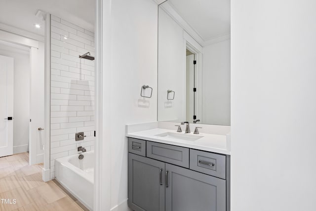 bathroom with vanity, crown molding, and tiled shower / bath