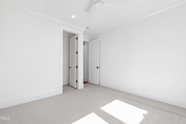 unfurnished room featuring light colored carpet, ceiling fan, and crown molding