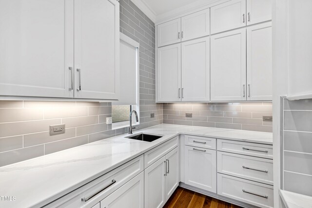 kitchen featuring dark hardwood / wood-style flooring, white cabinetry, decorative backsplash, and sink