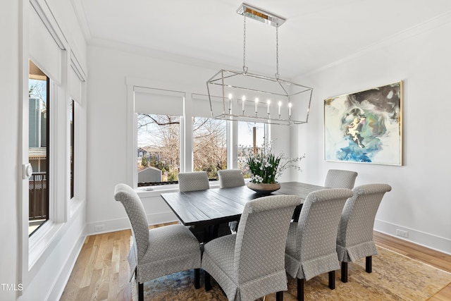 dining area featuring light wood-type flooring and ornamental molding