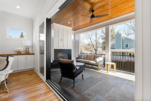 sunroom with ceiling fan and wood ceiling