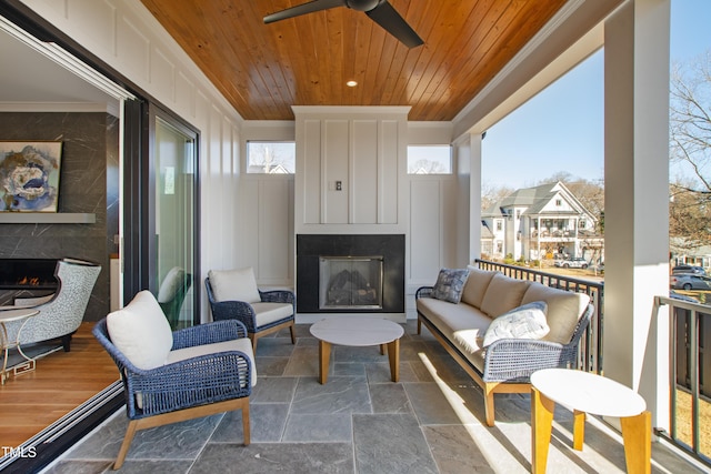 exterior space with a premium fireplace, ceiling fan, and wooden ceiling