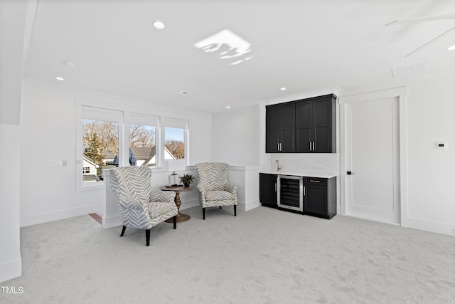 living area with ornamental molding, indoor bar, beverage cooler, and light carpet