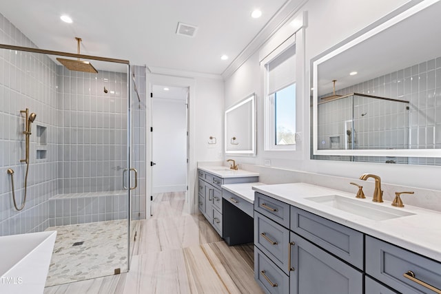 bathroom with a shower with door, vanity, and ornamental molding