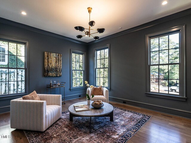 sitting room featuring hardwood / wood-style flooring, a notable chandelier, and crown molding