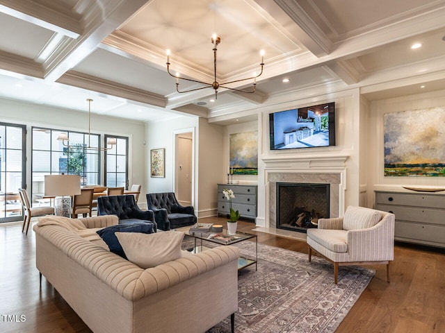 living room featuring a premium fireplace, beamed ceiling, a chandelier, and coffered ceiling