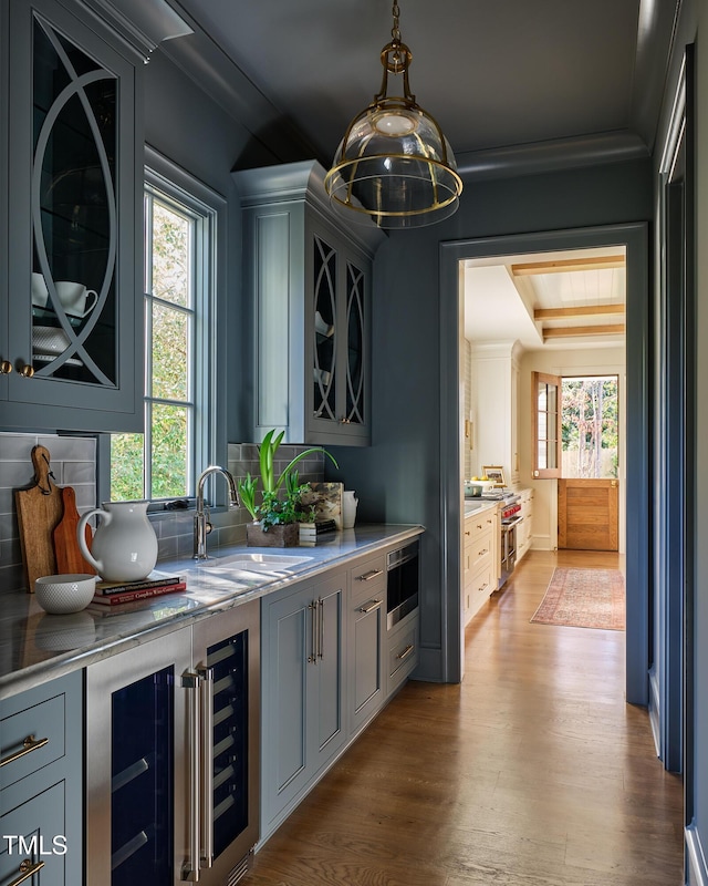 1307 Mayfair Rd, Raleigh, NC 27608 - bar featuring beverage cooler, wood finished floors, stainless steel range, backsplash, and hanging light fixtures