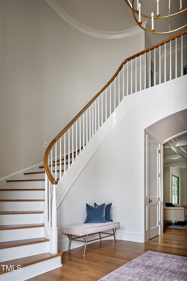 1307 Mayfair Rd, Raleigh, NC 27608 - staircase with wood finished floors, a towering ceiling, arched walkways, and crown molding