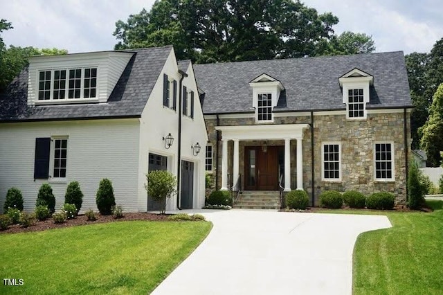 1307 Mayfair Rd, Raleigh, NC 27608 - view of front of home with a front lawn, concrete driveway, an attached garage, and stone siding