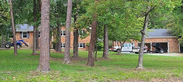 view of yard featuring driveway and a garage