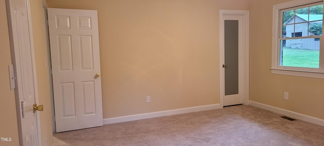interior space featuring carpet floors, visible vents, and multiple windows