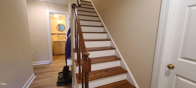 stairway with baseboards and wood finished floors