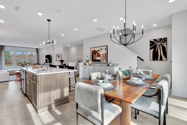 dining room with a notable chandelier, light hardwood / wood-style flooring, and sink