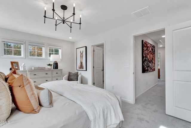 carpeted bedroom with ensuite bathroom and a notable chandelier