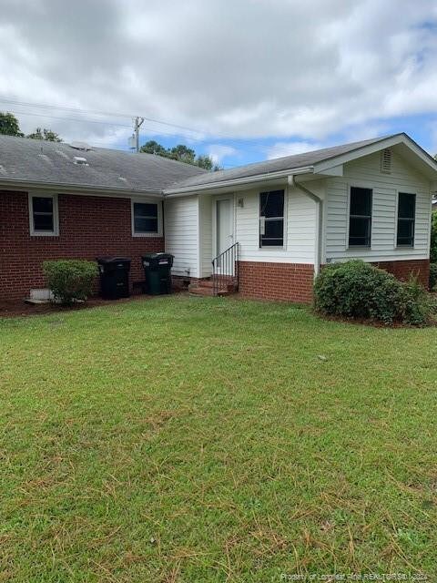 back of house with a lawn