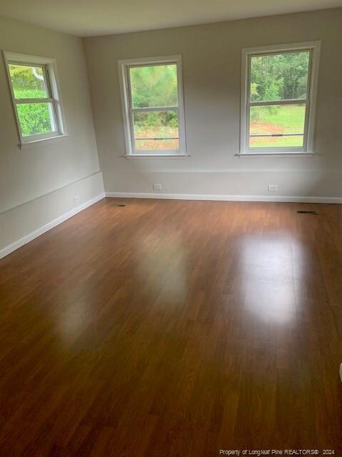 unfurnished room featuring dark wood-type flooring