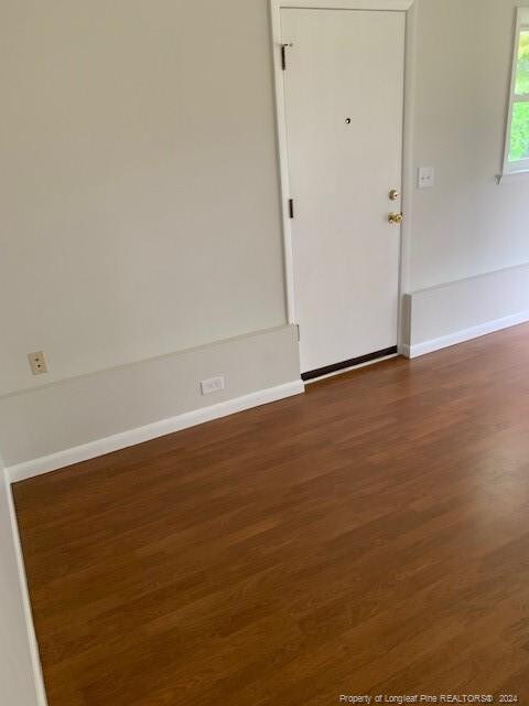 empty room with dark hardwood / wood-style flooring