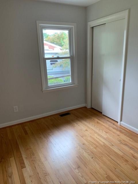 unfurnished bedroom featuring a closet and light hardwood / wood-style floors