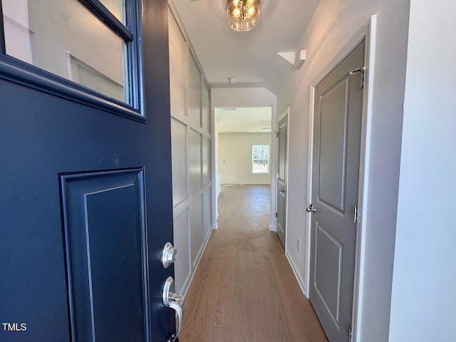 corridor featuring baseboards and wood finished floors