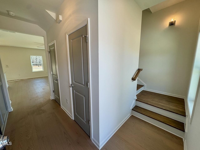 corridor featuring stairs, wood finished floors, and baseboards