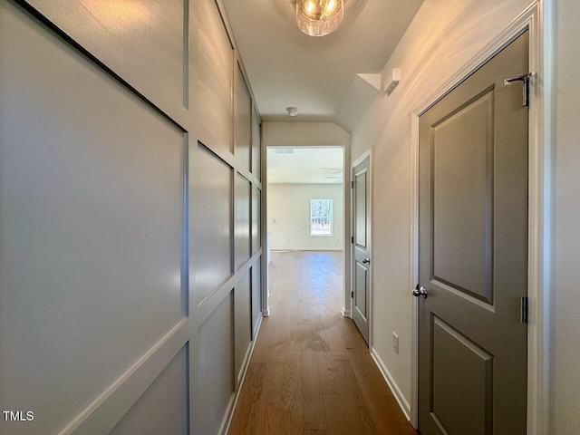 hall featuring dark wood-type flooring and baseboards