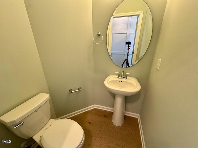 bathroom with wood finished floors, toilet, and baseboards