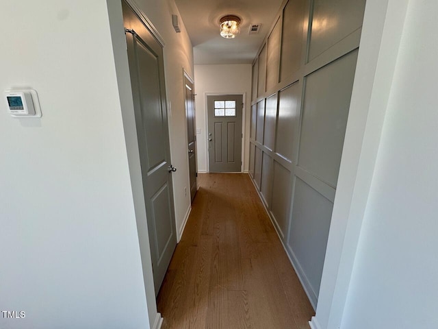 corridor with visible vents and dark wood-style flooring