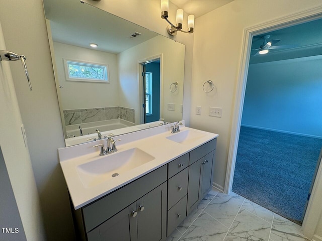 full bath with marble finish floor, visible vents, a garden tub, and a sink