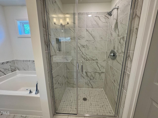 bathroom featuring a stall shower and a bath