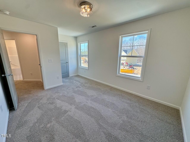 unfurnished bedroom with carpet, visible vents, and baseboards