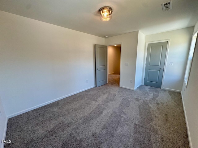 unfurnished bedroom with carpet flooring, visible vents, and baseboards