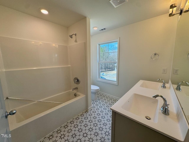 full bath featuring toilet, double vanity, a sink, and visible vents