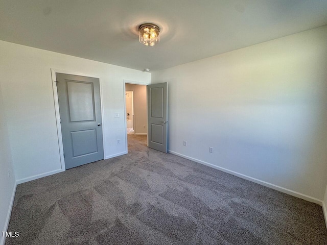 unfurnished bedroom featuring carpet and baseboards