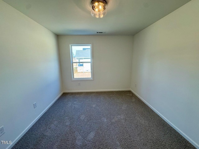 empty room featuring baseboards, visible vents, and carpet flooring