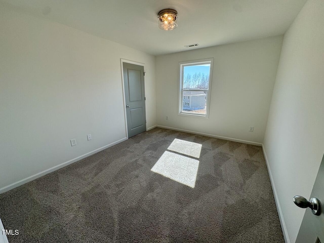 carpeted empty room featuring baseboards and visible vents