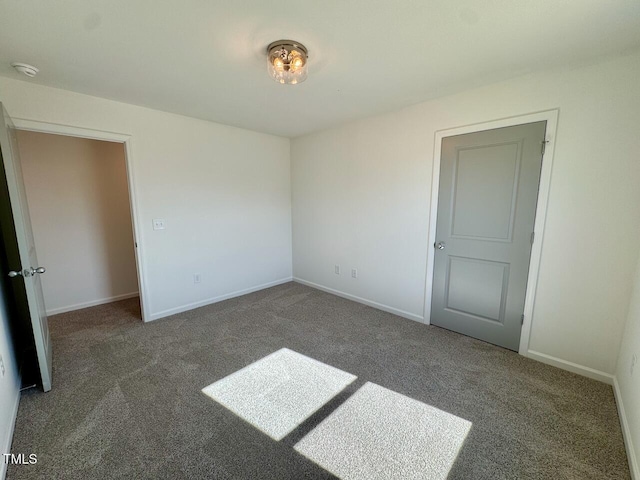 unfurnished bedroom with carpet flooring and baseboards